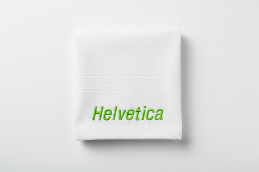 Embroidered Helvetica italic font in green on white towel